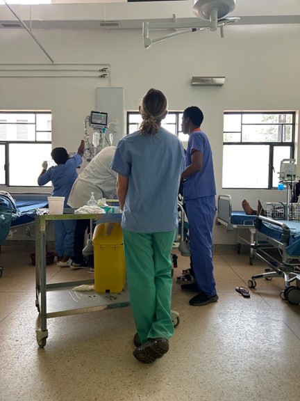 Skeeter Welder observing Trauma Nursing Fundamentals course participants caring for a patient in Accidents and Emergency at the Butaro Level Two Teaching Hospital in Butaro, Rwanda, March 2025